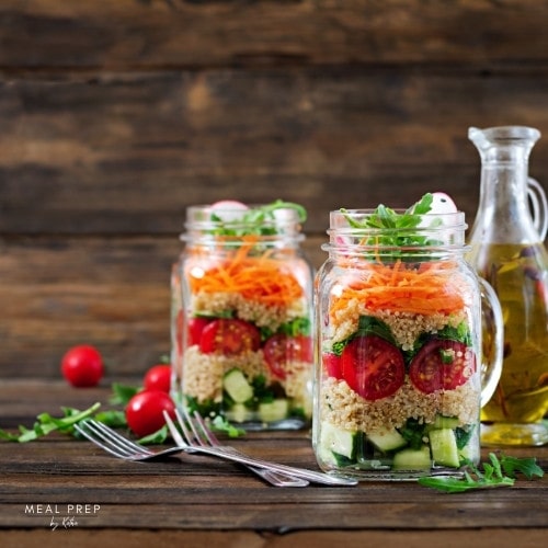 Mealprep Quinoa-Salat im Glas mit Gurke, Tomaten, Karotten und Rucola – gesundes vegetarisches Mittagessen to go